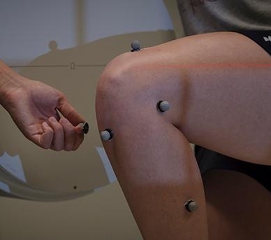 Motion tracking devices shown on a test subject's knee to test human dynamics in a lab.